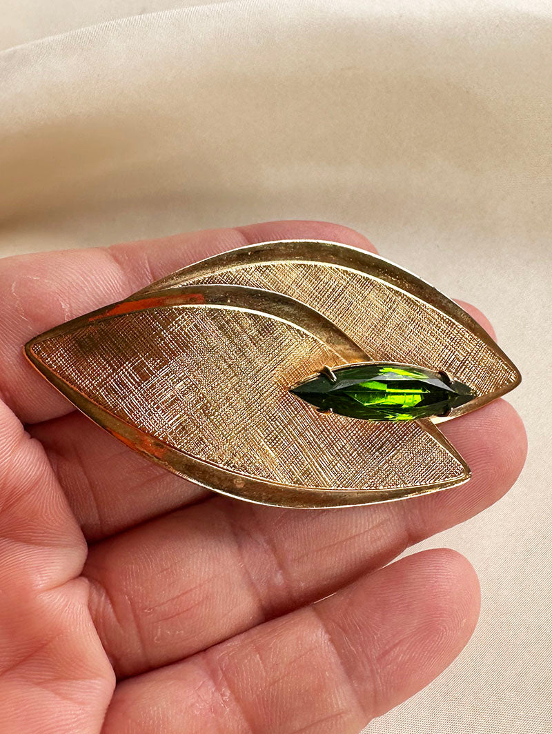 Gouden blaadjes broche met groene steen