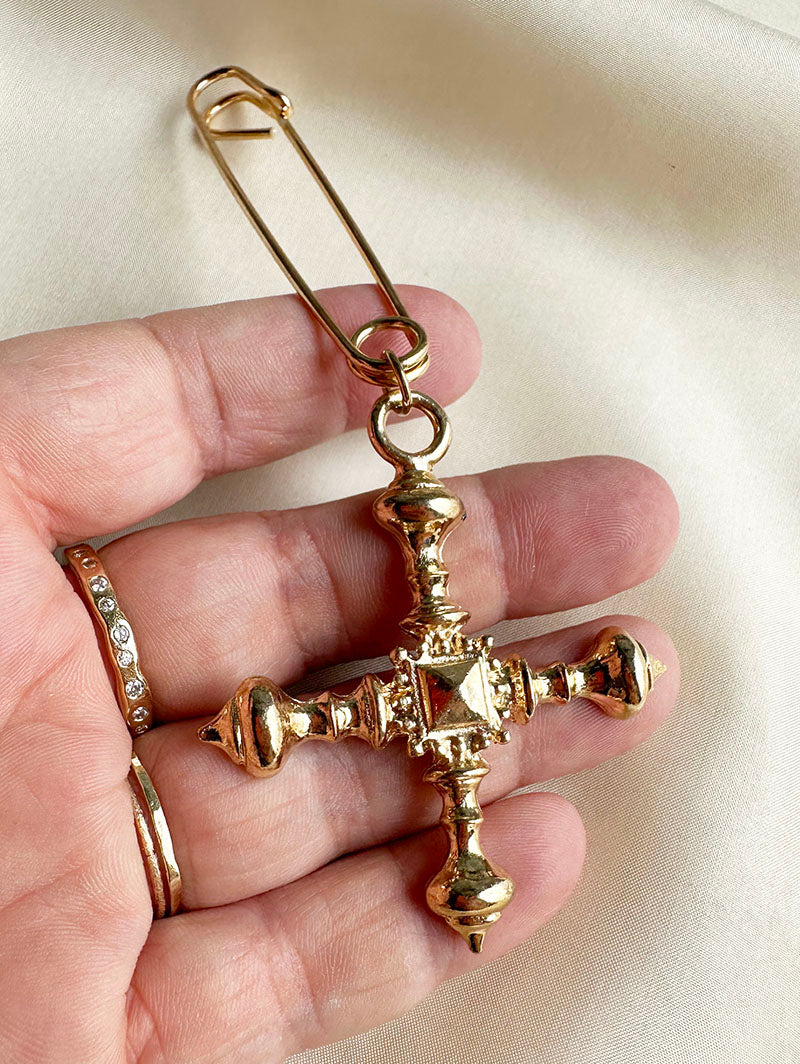 Gouden crucifix aan speld