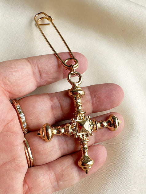 Gouden crucifix aan speld