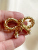 Vergulde strik broche met faux parels