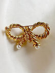 Vergulde strik broche met faux parels