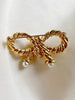 Vergulde strik broche met faux parels