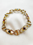 Gouden schakelarmbandje met gekleurde steentjes