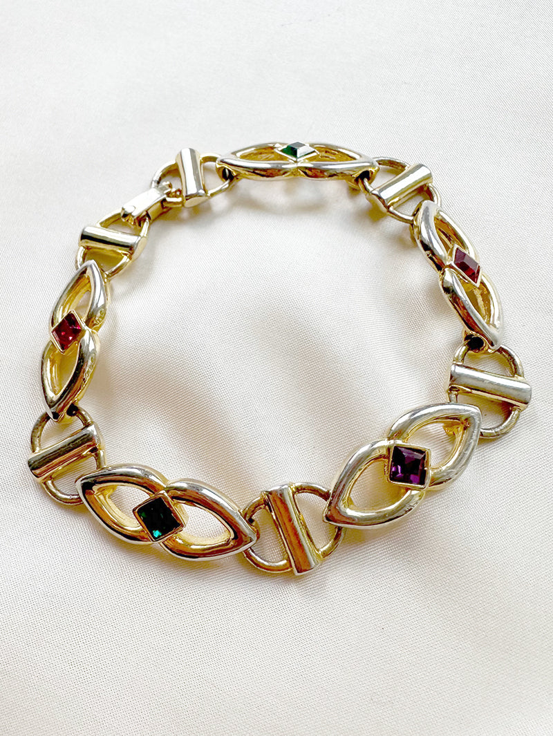 Gouden schakelarmbandje met gekleurde steentjes