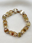 Gouden schakelarmbandje met gekleurde steentjes
