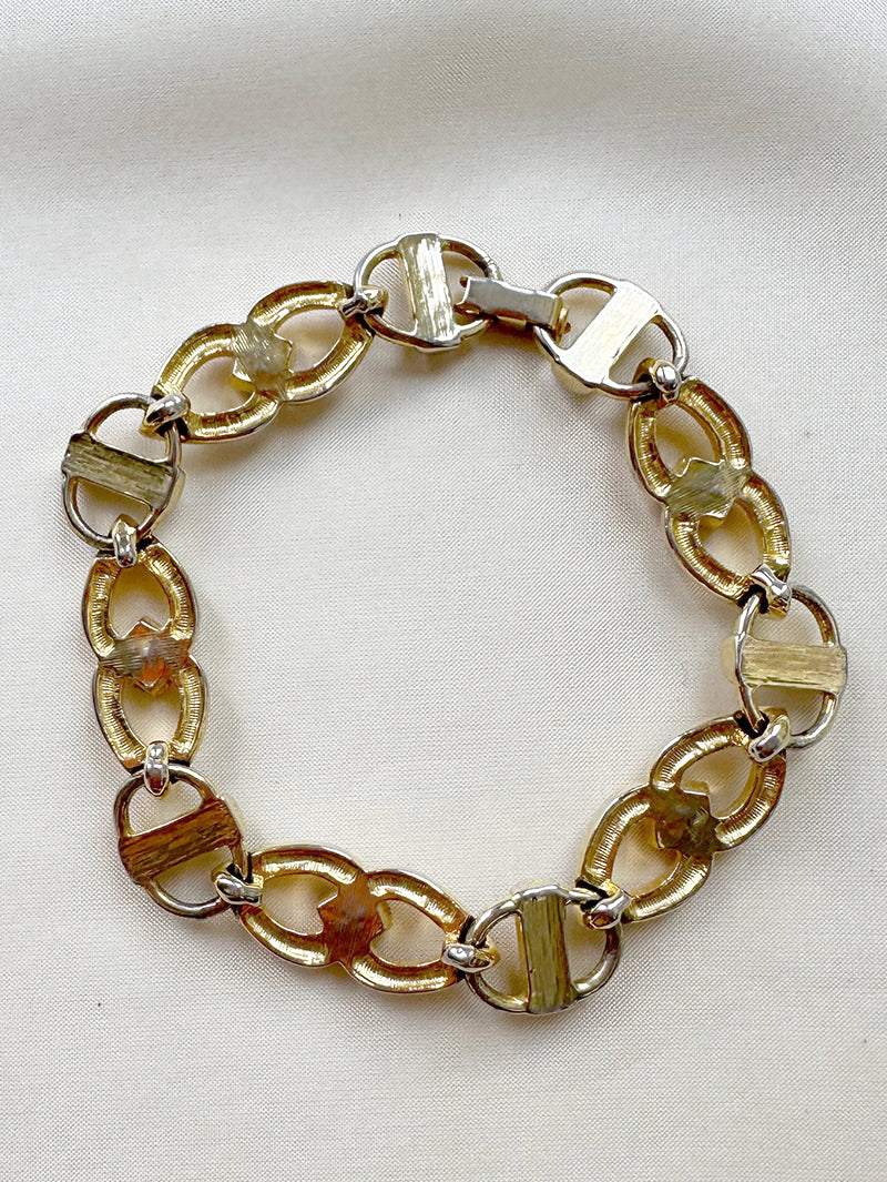 Gouden schakelarmbandje met gekleurde steentjes