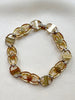 Gouden schakelarmbandje met gekleurde steentjes